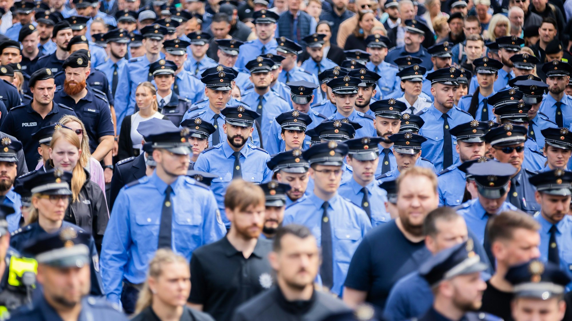 Polizisten nehmen in Berlin an einem Schweigemarsch in Gedenken an den durch einen Messerangriff in Mannheim zu Tode gekommenen Polizisten teil.