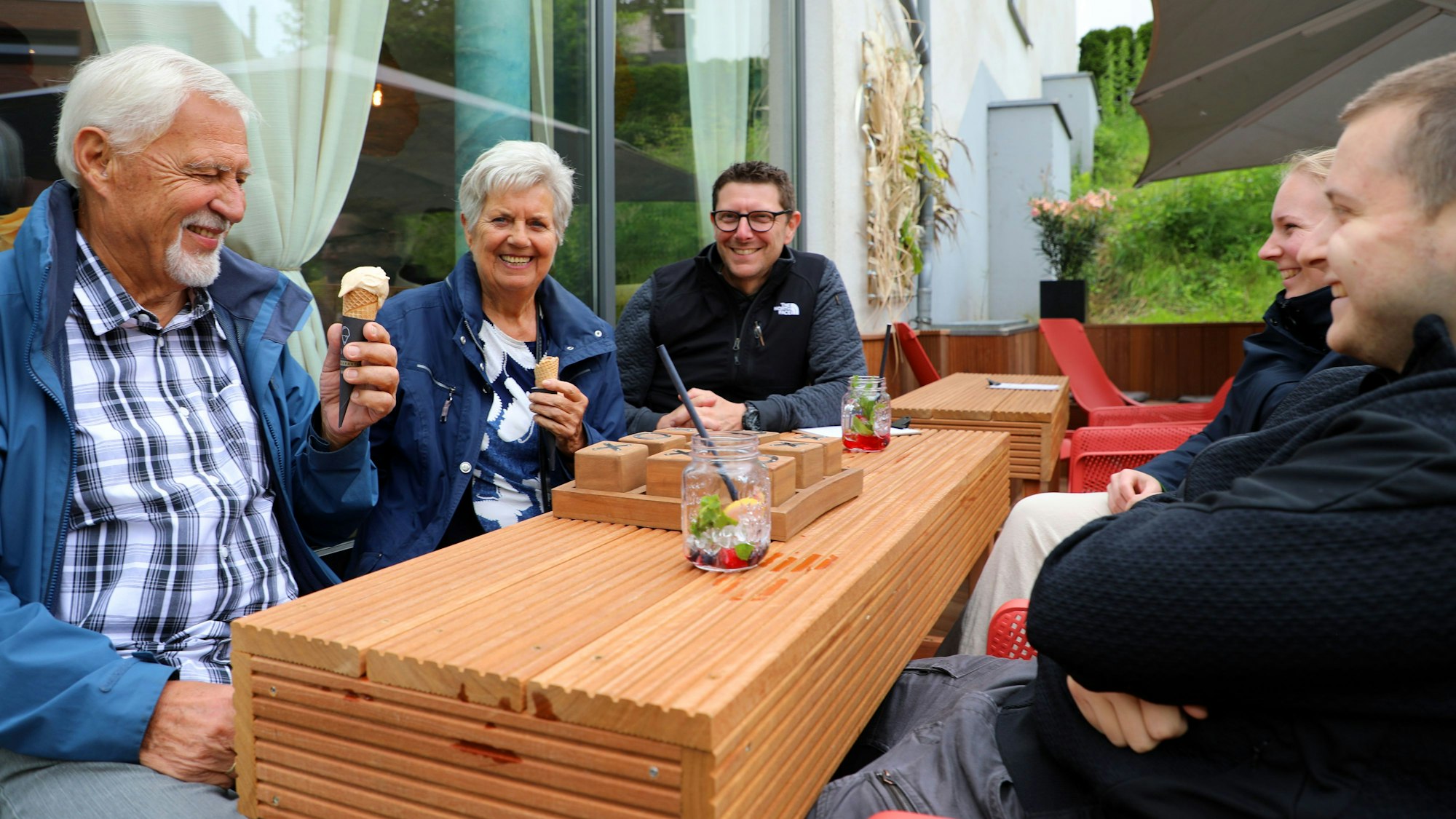 Menschen sitzen auf der Terrasse des Café Esperanza an der Bensberger Straße 260c im Herzen von Rösrath-Forsbach, essen Eis und trinken etwas.