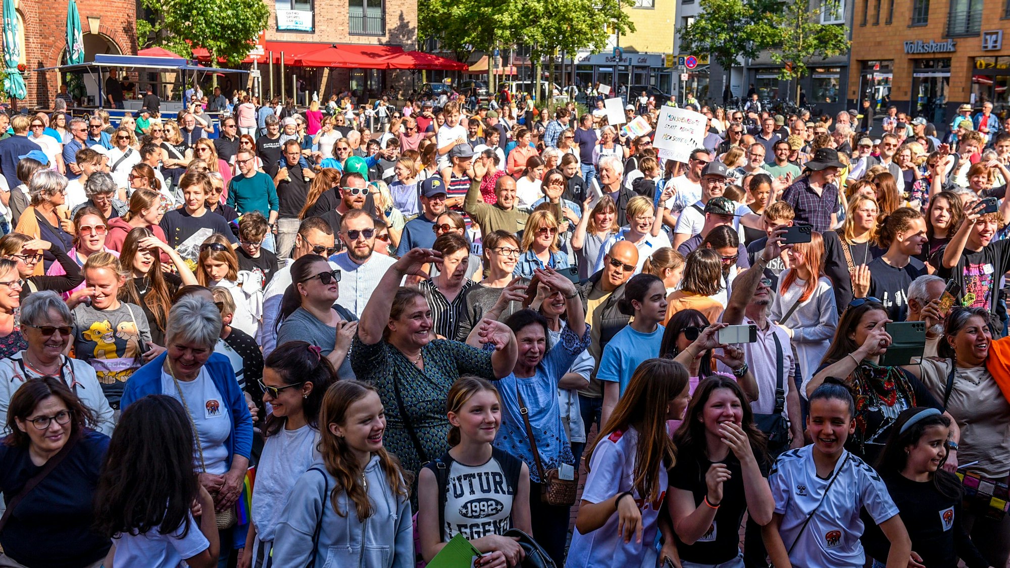 Auf dem Bild ist eine Menschenmenge auf dem Marktplatz Pulheim, die für Demokratie und Vielfalt demonstrieren.