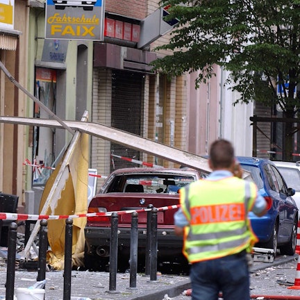 Ein Polizist sichert die Spuren der Explosion nach dem Nagelbombenanschlag in der Keupstraße