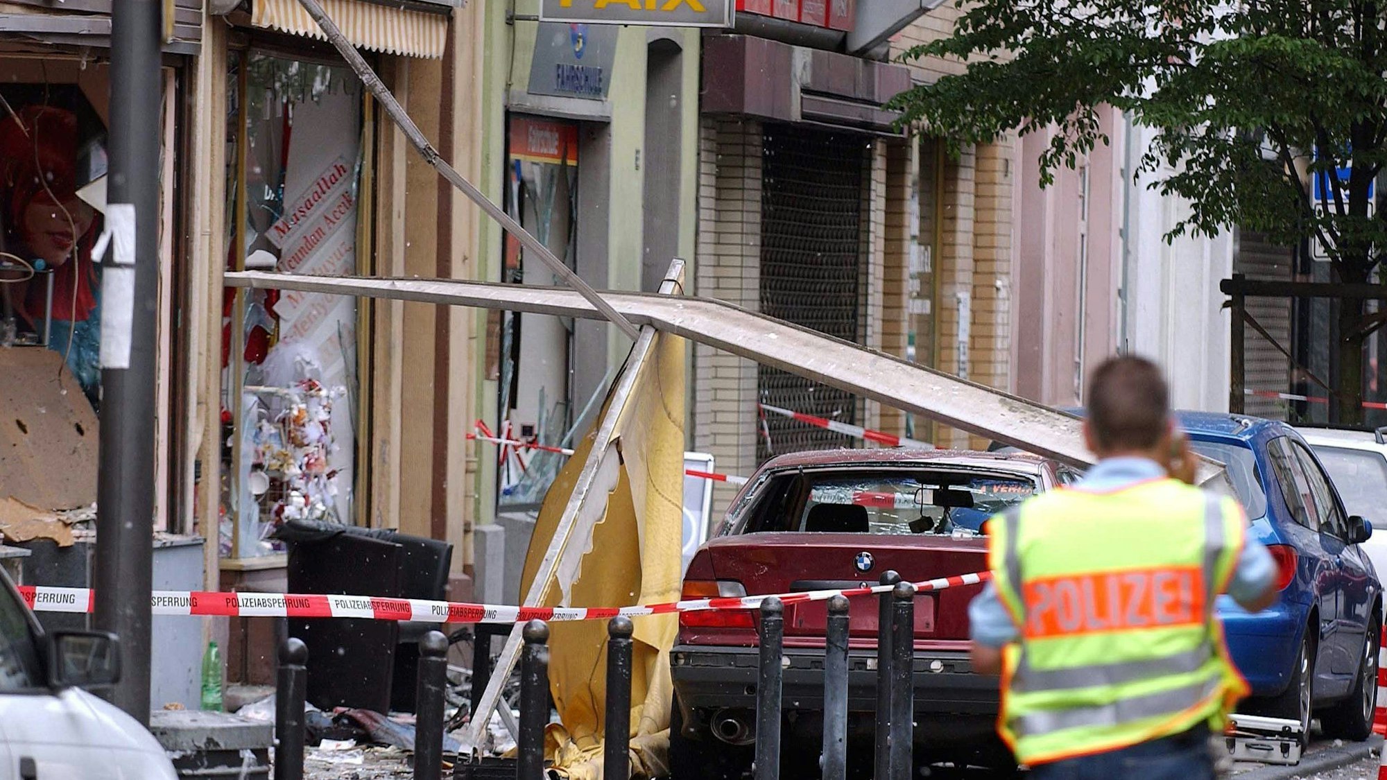 Ein Polizist sichert die Spuren der Explosion nach dem Nagelbombenanschlag in der Keupstraße