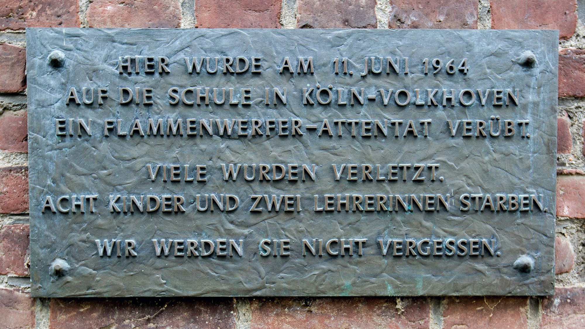 Gedenktafel zu Flammenwerfer-Attentat am 11.6.1964 an der ehemaliger Volksschule Volkhovener Weg.