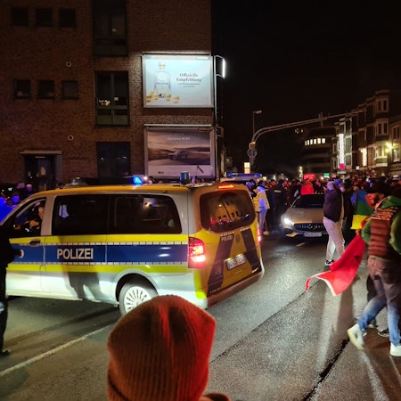 Auf dem Foto sind feiernde marokkanische Fans in der Bergheimer Innenstadt nach einem Sieg ihrer Mannschaft bei der WM 2022 und Polizisten zu sehen.