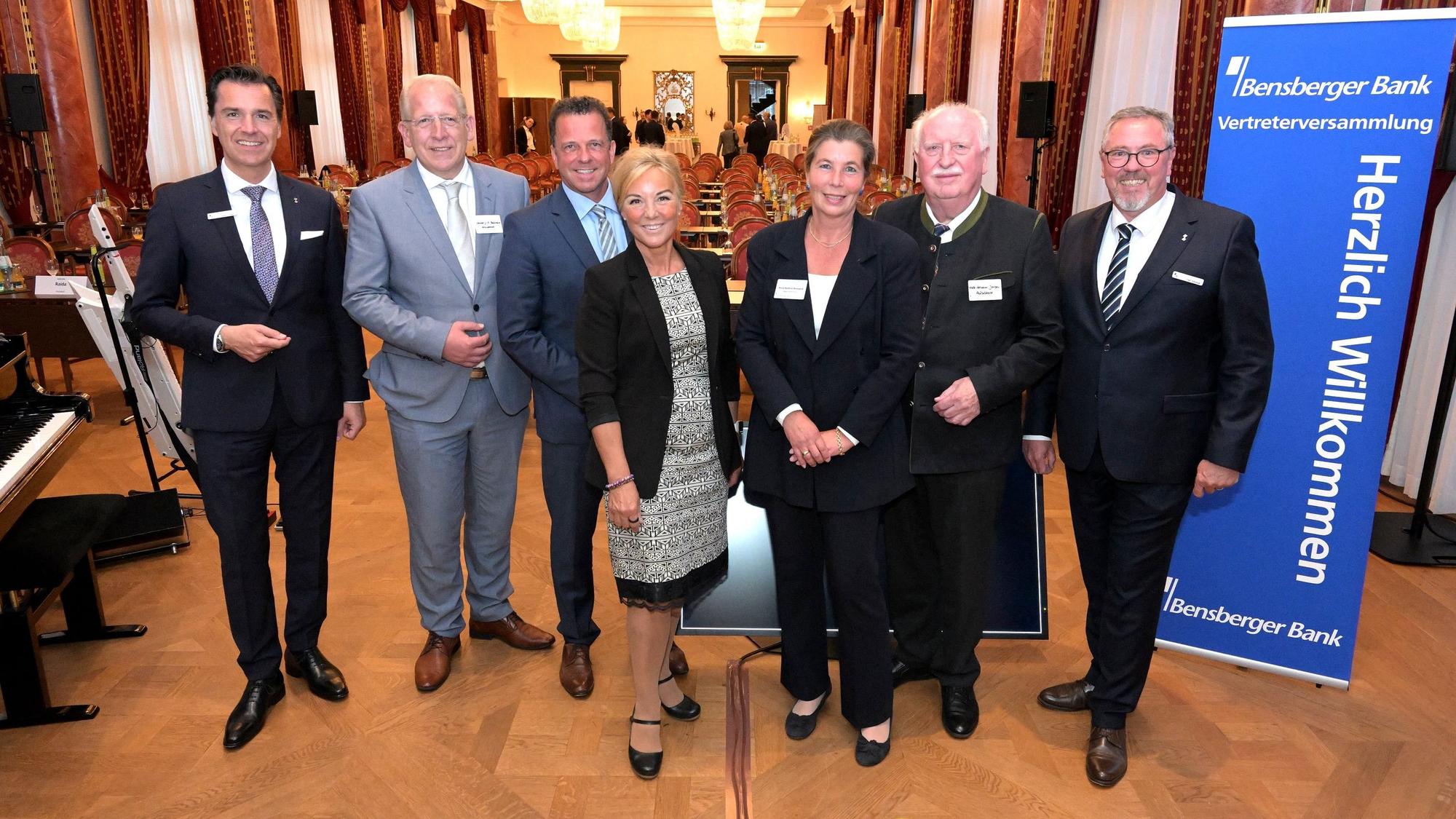 Sieben Menschen stehen vor einem Saal des Bensberger Schlosses.