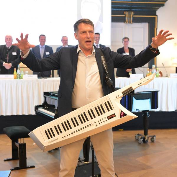 Ein Mann mit Umhängepiano macht Stimmung,