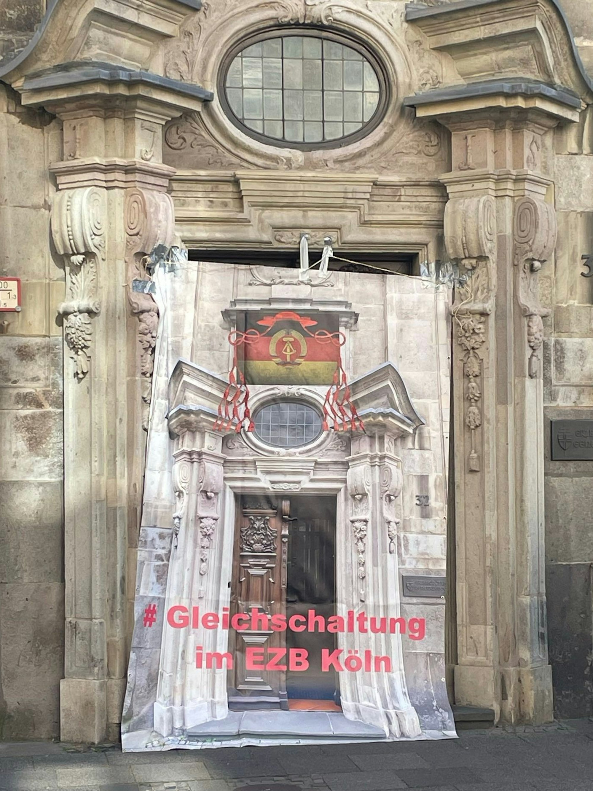 Gesamtansicht des mit einem Protestplakat verhängten Eingang zum Kölner Generalvikariat