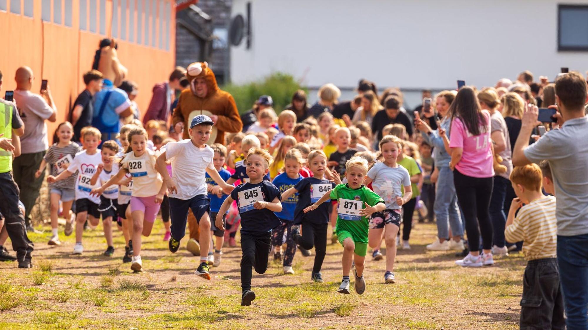 Zu sehen sind Kinder, die ein Wettrennen laufen.