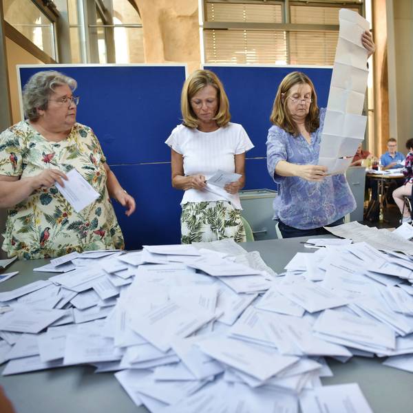 Drei Frauen und ein Mann öffnen die Briefwahlumschläge zur Europawahl in Zülpich.