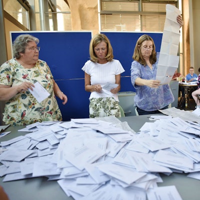 Drei Frauen und ein Mann öffnen die Briefwahlumschläge zur Europawahl in Zülpich.