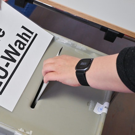 Brandenburg, Frankfurt (Oder): Eine Person steckt ihren Stimmzettel in eine Wahlurne mit der Aufschrift „Urne EU-Wahl“.