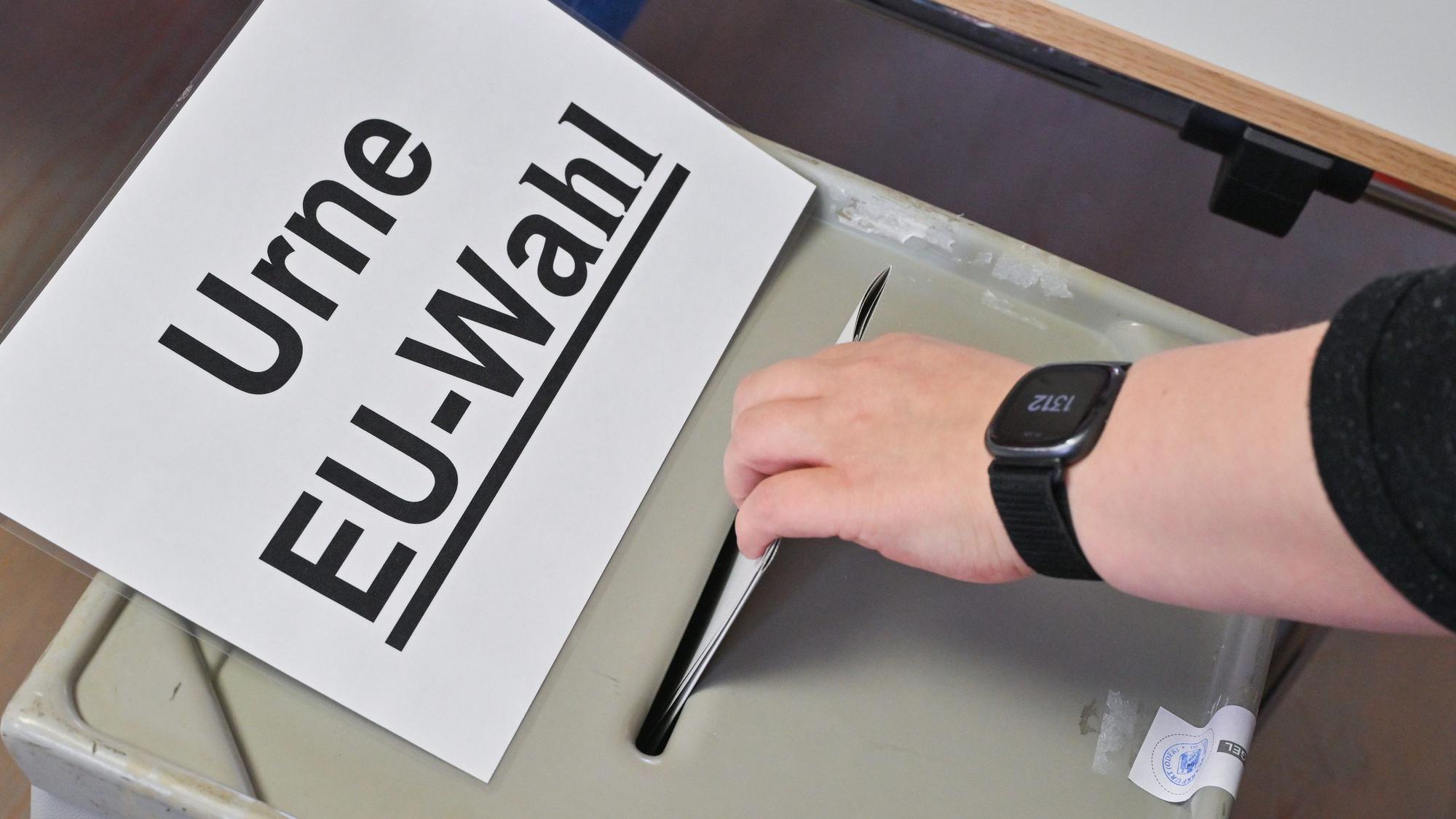 Brandenburg, Frankfurt (Oder): Eine Person steckt ihren Stimmzettel in eine Wahlurne mit der Aufschrift „Urne EU-Wahl“.