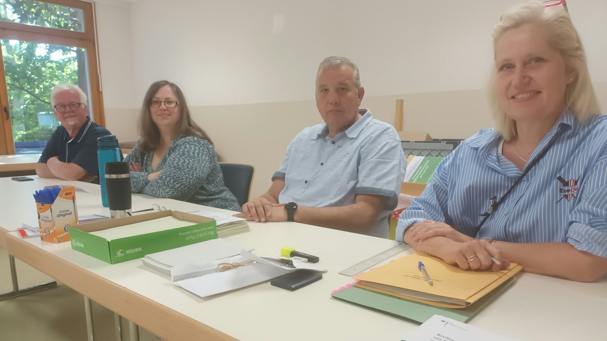 Vier Personen sitzen an einem Tisch