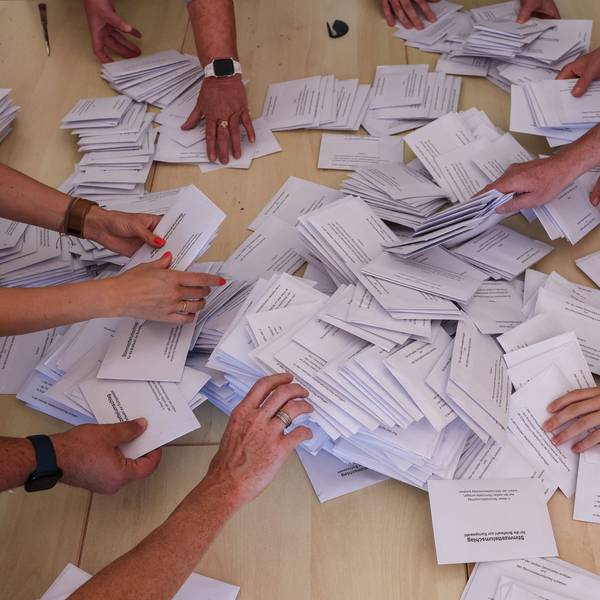 Sachsen-Anhalt, Halle: Zahlreiche Wahlhelfer nehmen sich bei der Stimmenauszählung die Umschläge mit den Briefwahlstimmen zur Europawahl.