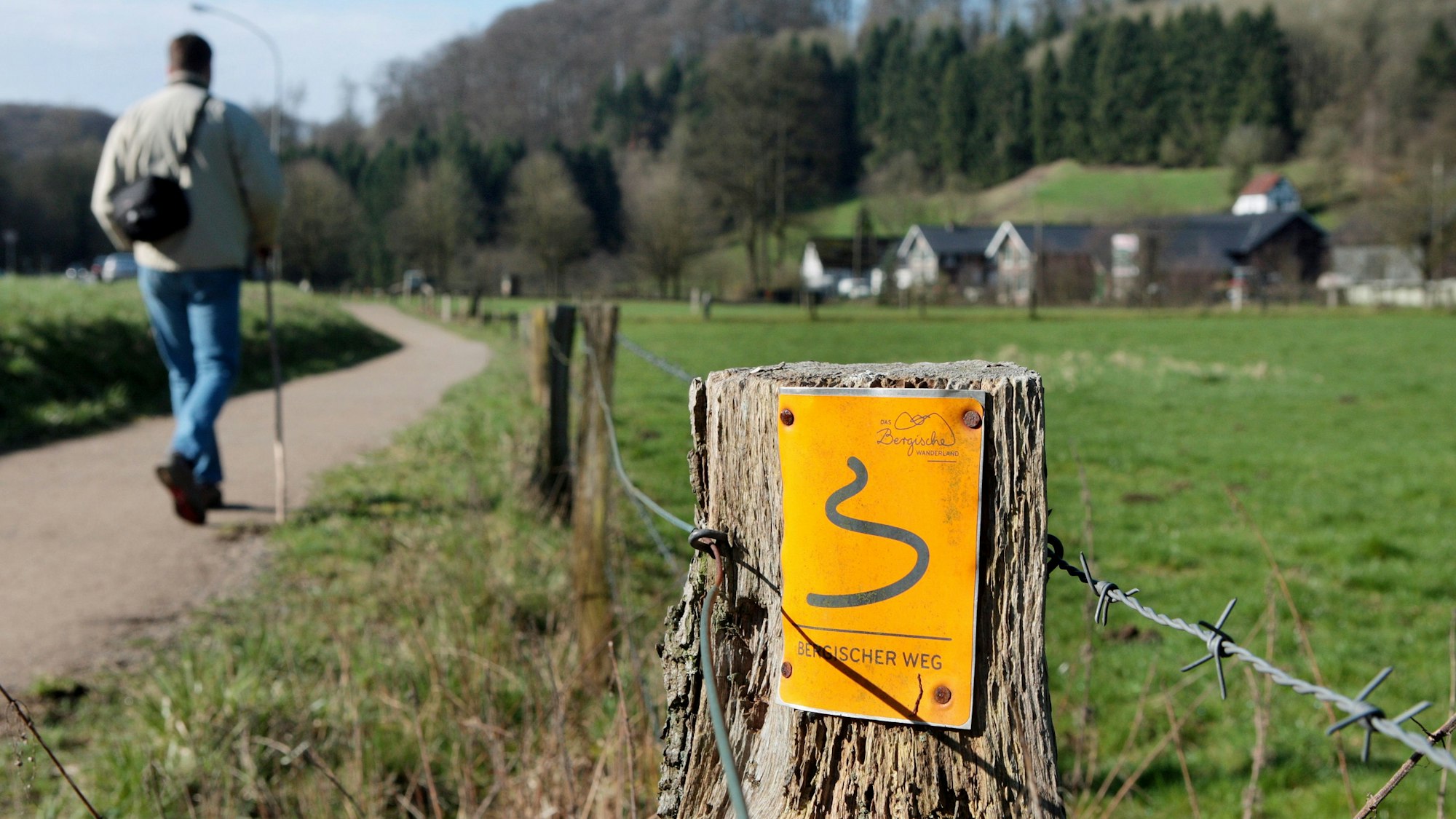 Ein Wanderer läuft auf dem Bergischen Weg durchs Strundetal bei Bergische Gladbach-Herrenstrunden.