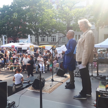 Nippeser Bezirksbürgermeisterin Diana Siebert und Najib Ramz auf der Bühne vor dem Publikum