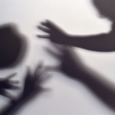Das Symbolbild zum Thea häusliche Gewalt zeigt Silhouette von zwei Menschen, die bedrohlich die Arme ausstrecken