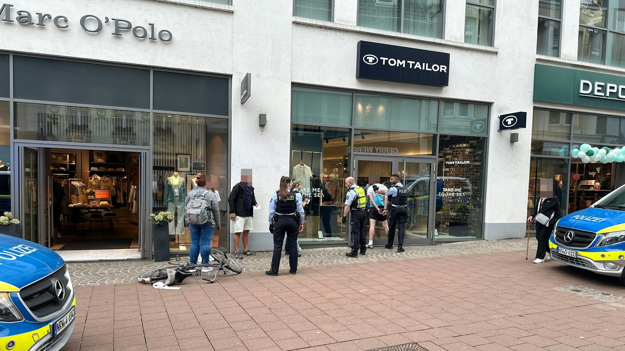 Polizeieinsatz in der Siegburger Innenstadt an der Bahnhofstraße, ein Verdächtiger ist mit Handschellen gefesselt.