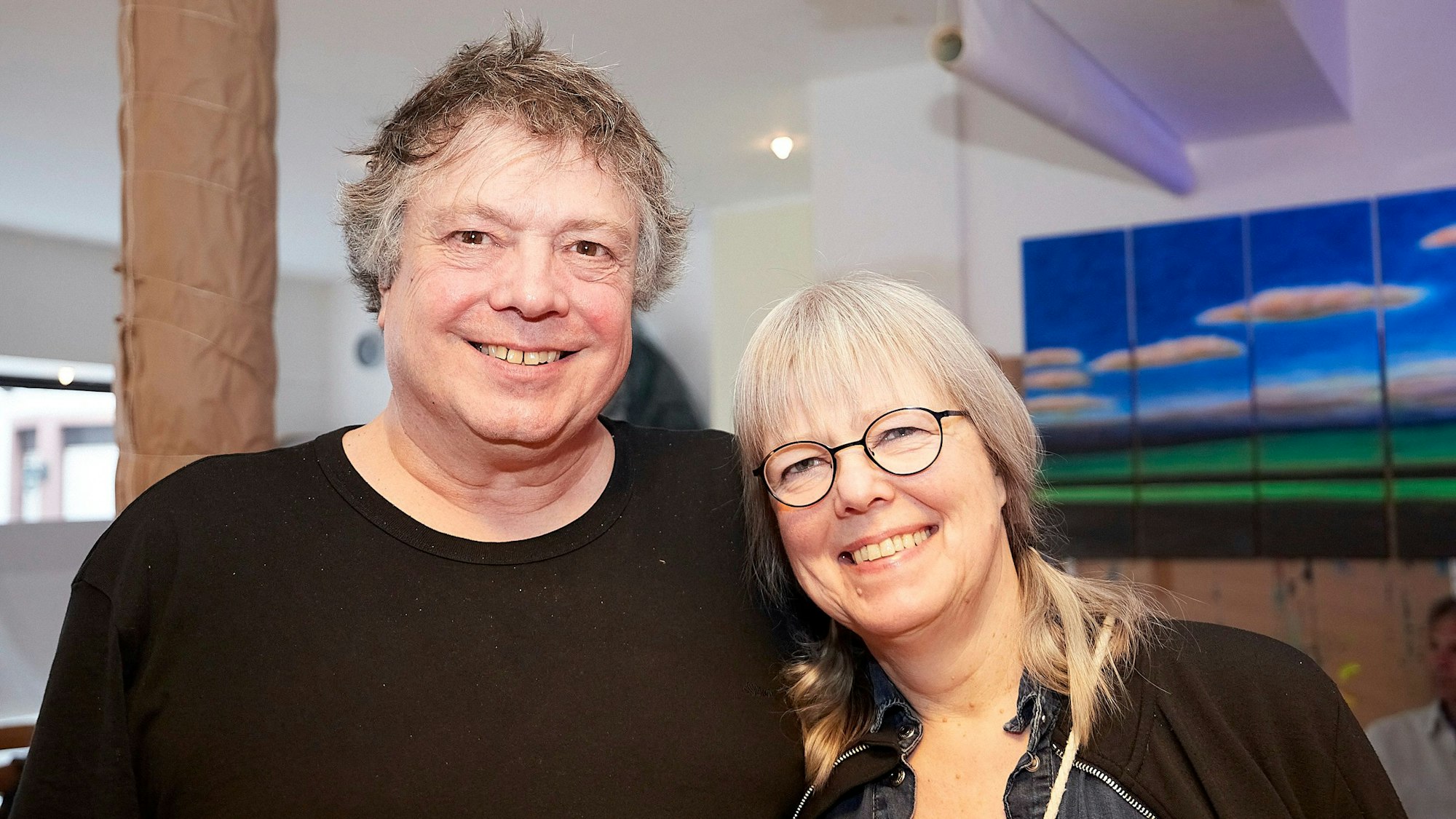 Eine Frau und ein Mann, Silvia Kock und Hartwig Kausch, stehen Arm in Arm in ihrem Kunstatelier in Blankenheim.