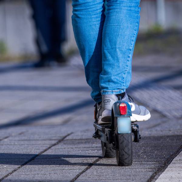 Eine Person fährt auf einem E-Scooter.