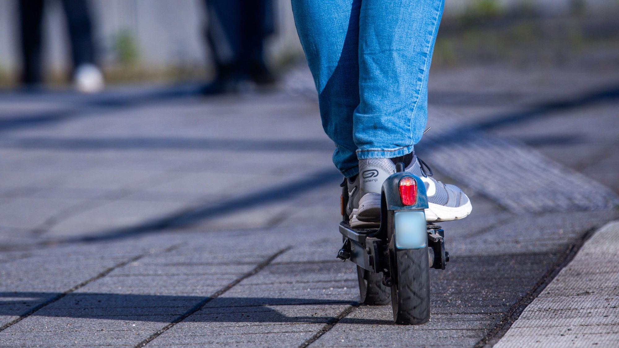 Eine Person fährt auf einem E-Scooter.
