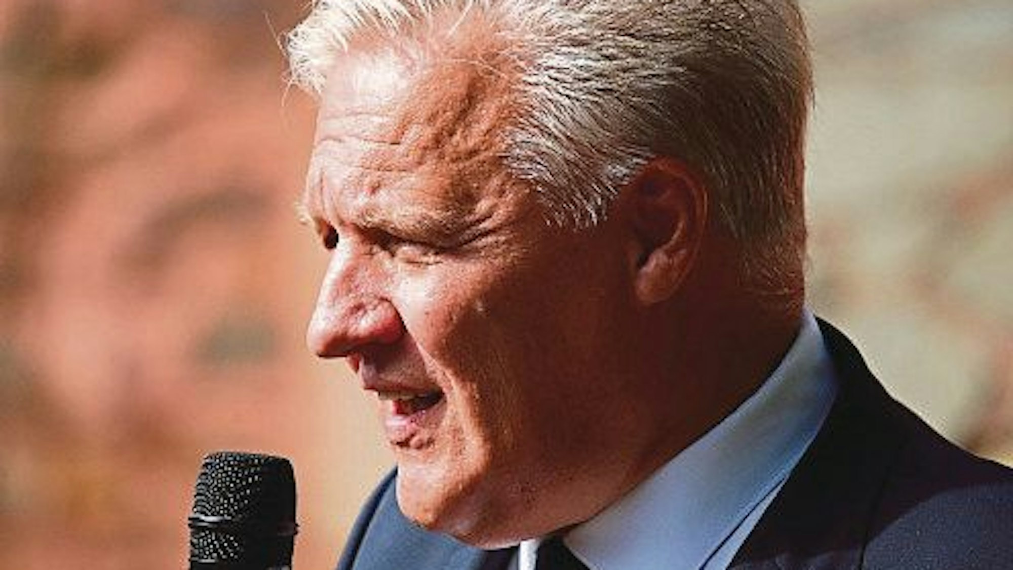 Die Staatsanwaltschaft Düsseldorf ermittelt gegen Landrat Wolfgang Spelthahn. er ist ihm Halbporträt an einem Mikrofon zu sehen.