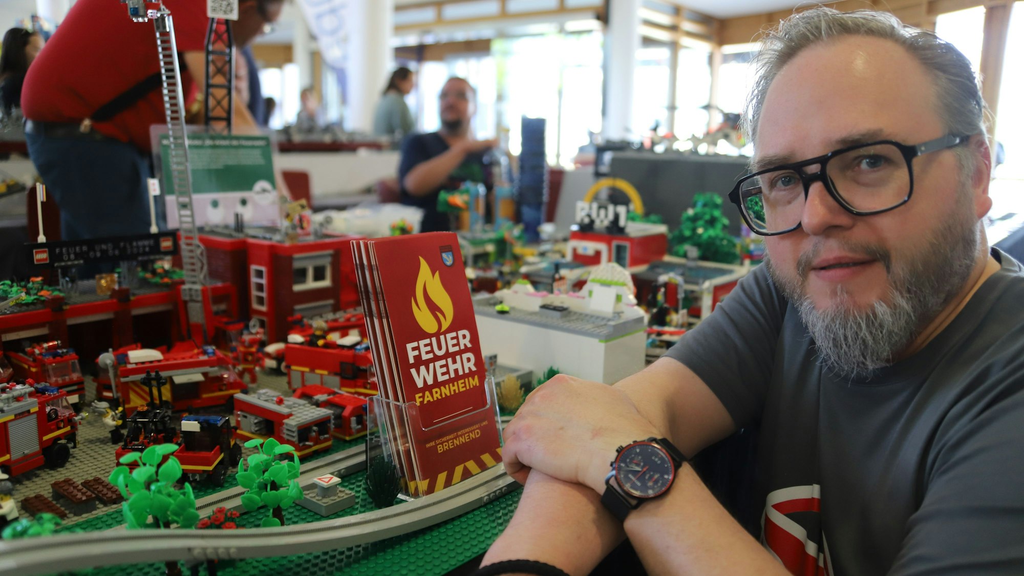 Maik Waterman sitzt neben seiner von ihm erfundenen Feuerwehr Farnheim, gebaut aus Klemmbausteinen.