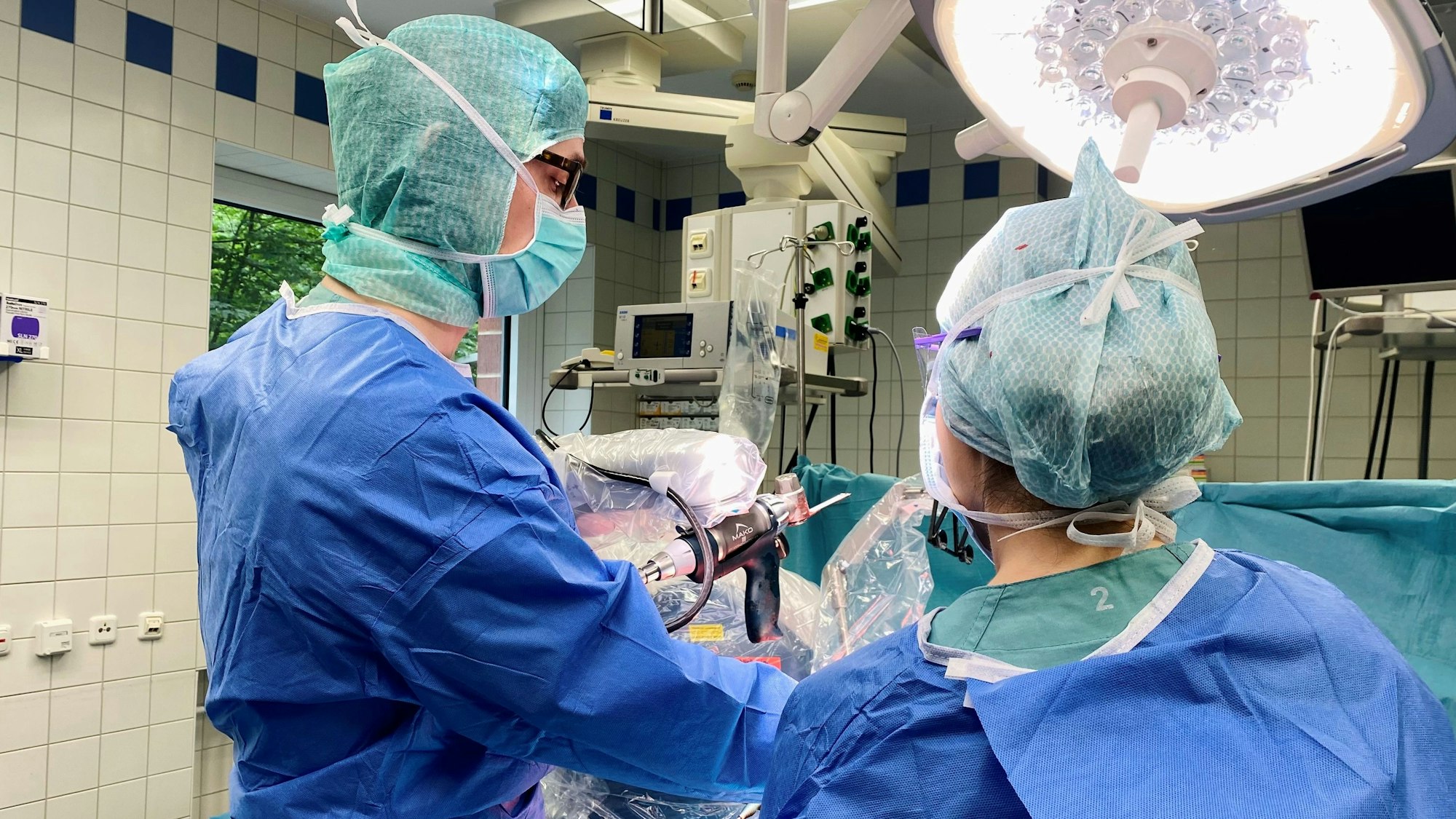 Der neue Roboter am Klinikum Leverkusen unterstützt die Ärztinnen und Ärzte seit März bei Operationen. Leonard Bastian, Chefarzt der Klinik für Orthopädie und Unfallchirurgie, zeigt das Verfahren während einer Operation.