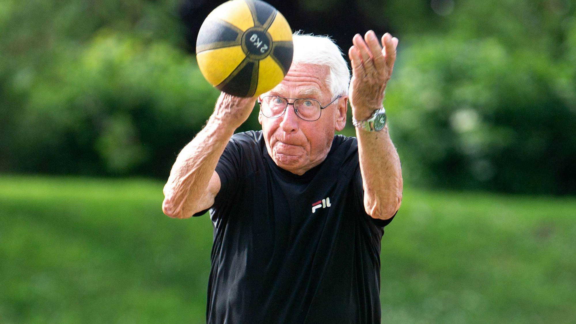 Ein Seniorensportler wirft einen Ball.