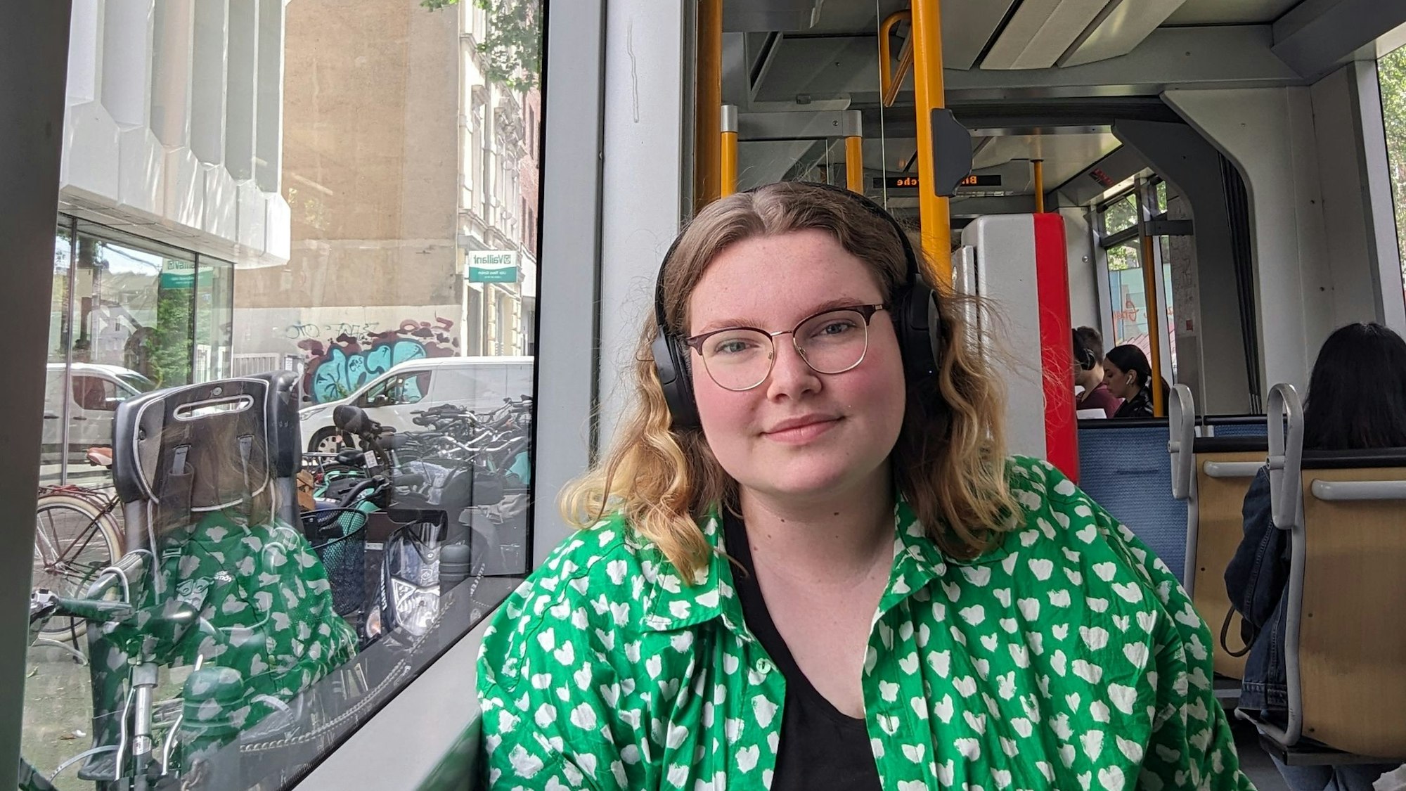 Eine junge Frau sitzt in einer Bahn.