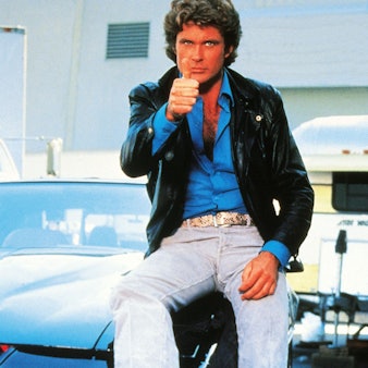 David Hasselhoff sitzt auf K.I.T.T. und zeigt den Daumen hoch.