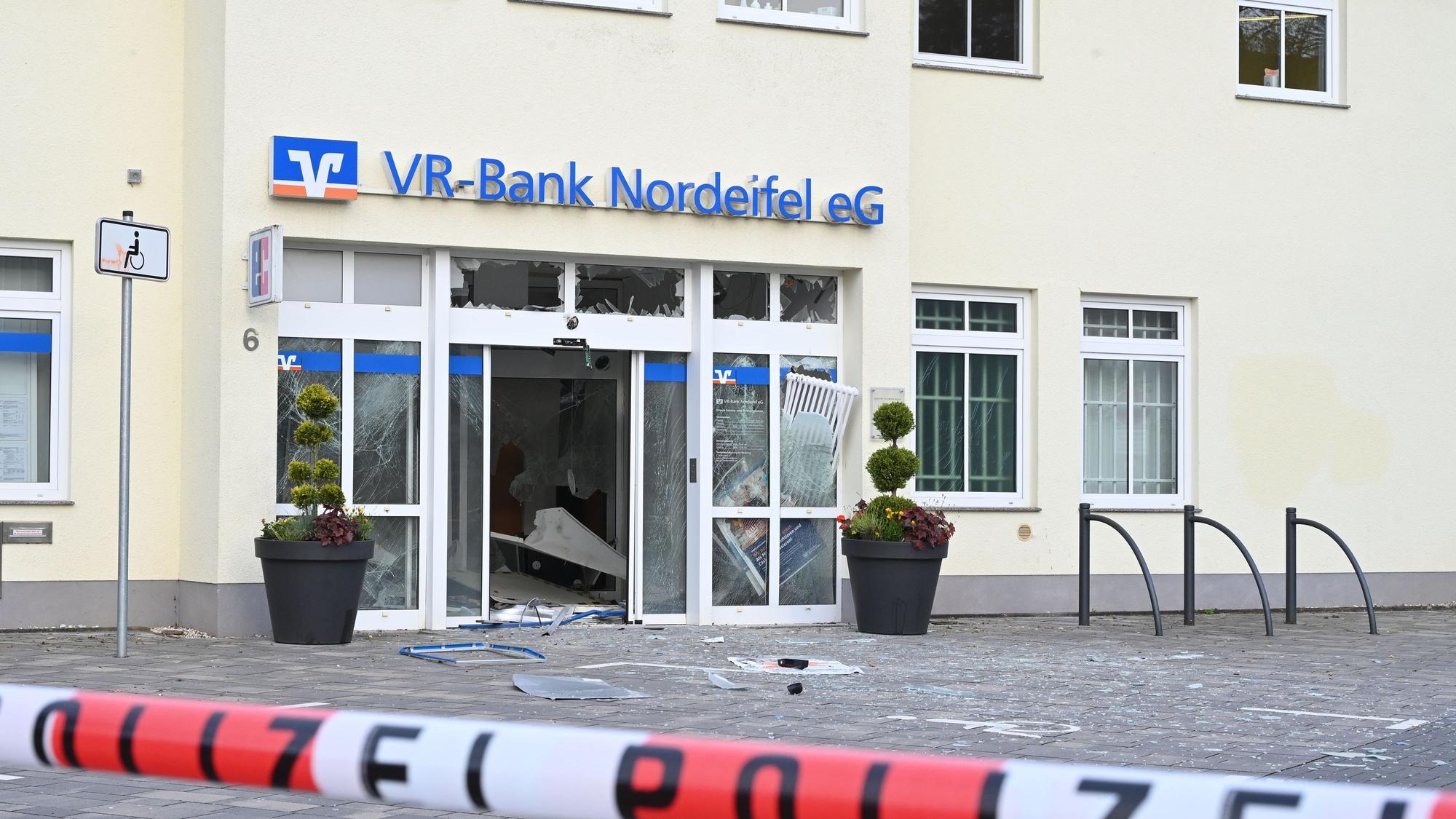 Vor dem Gebäude mit dem blauen Schriftzug der VR-Bank liegen Splitter, ein rot-weißes Band mit der Aufschrift Polizei sperrt den Tatort ab.