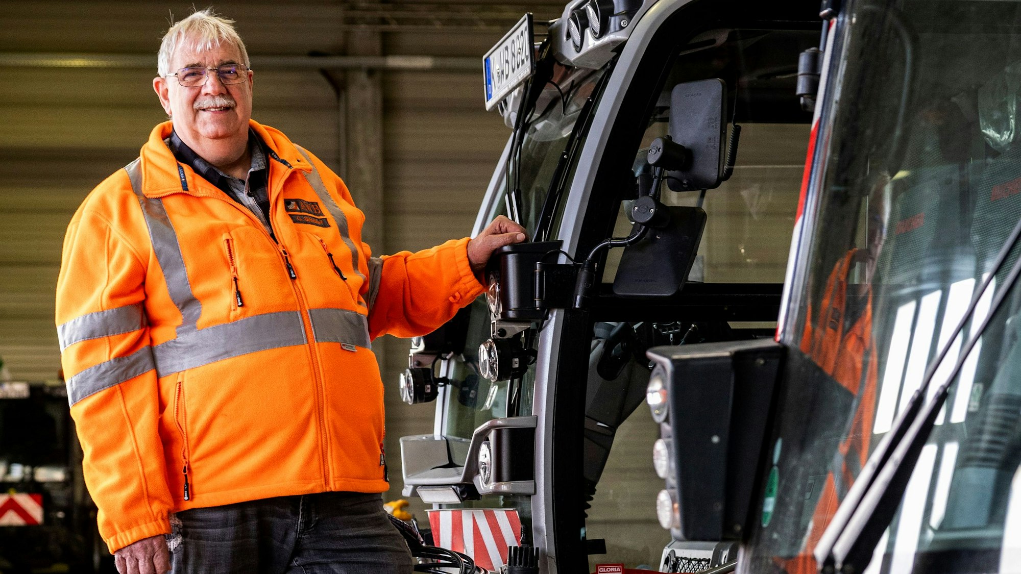 Zu sehen ist Gerhard Bittdorf, Einsatzleiter der Abfallwirtschaftsbetriebe (AWB), neben einem Fahrzeug der Stadtreinigung.
