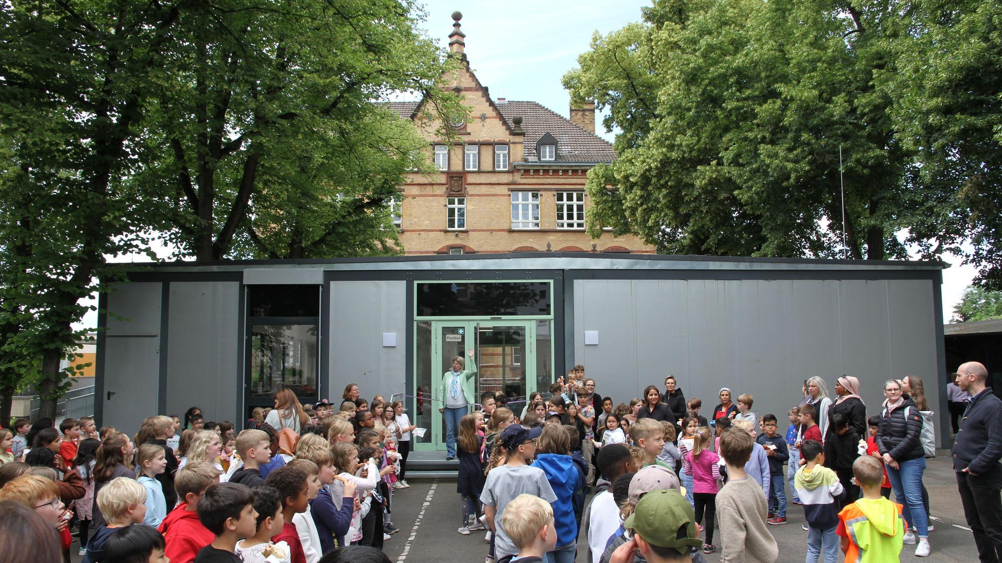 Schüler vor einem Raumcontainer auf einem Schulhof
