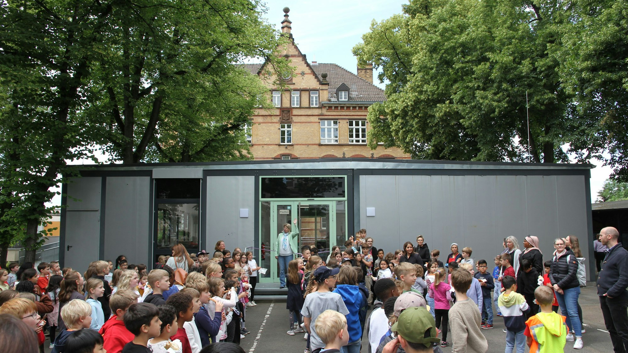Schüler vor einem Raumcontainer auf einem Schulhof