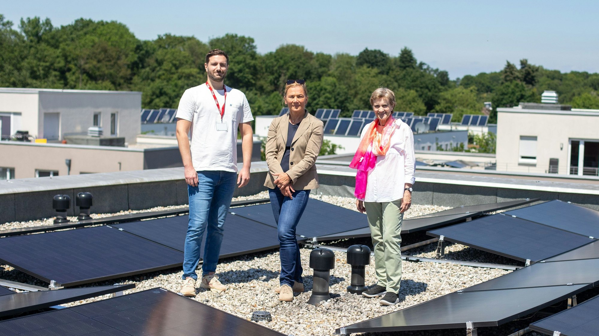 Inmitten einer der neuen Photovoltaik-Anlagen auf einem Dach eines Hauses im Waldbadviertel in Ostheim stehen Moritz Wolf (v.l.), Kathrin Möller und Claudia Greven-Thürmer