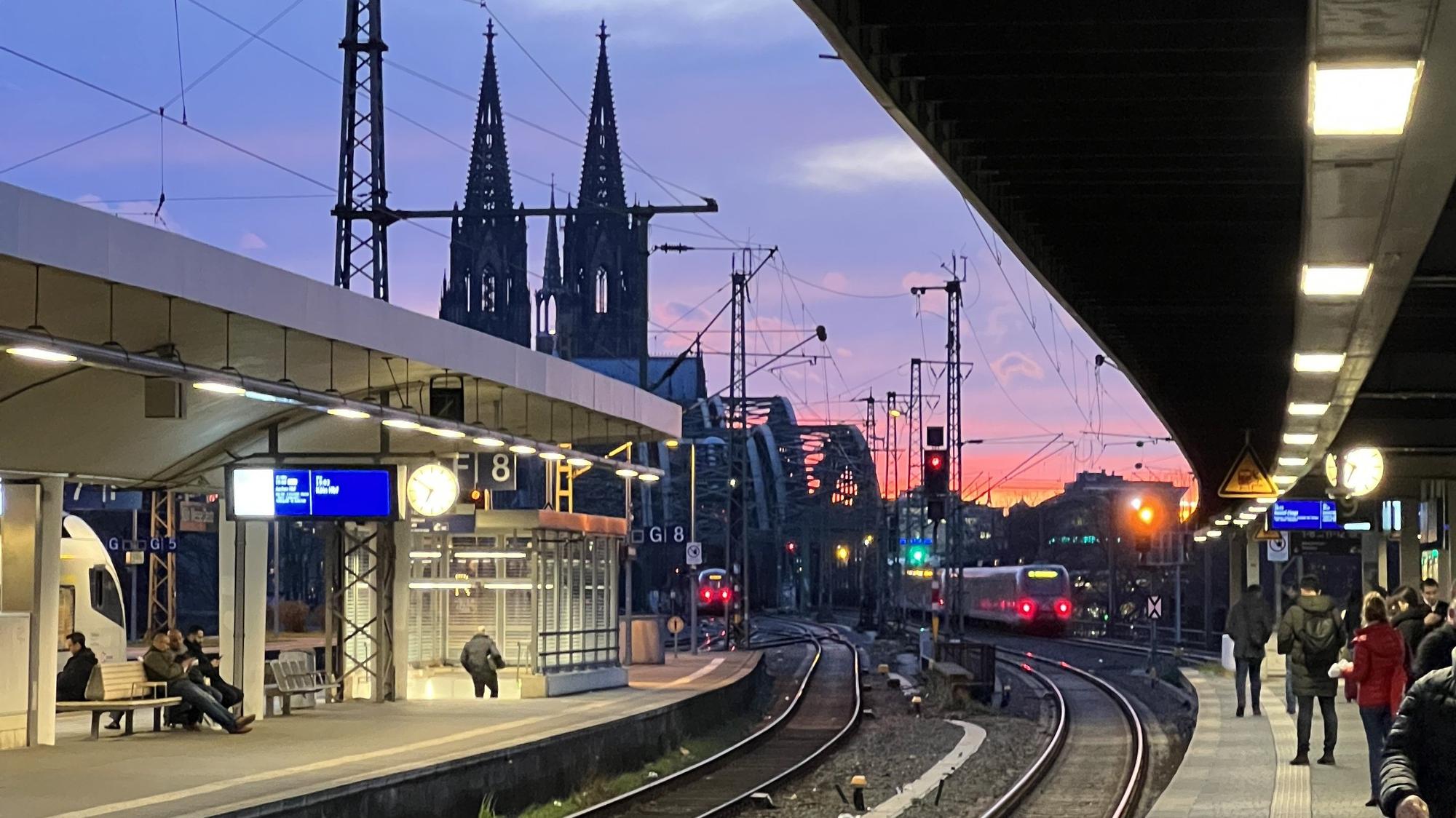 Der Bahnhof in Köln-Deutz im Abendlicht, im Hintergrund die Türme des Kölner Doms.