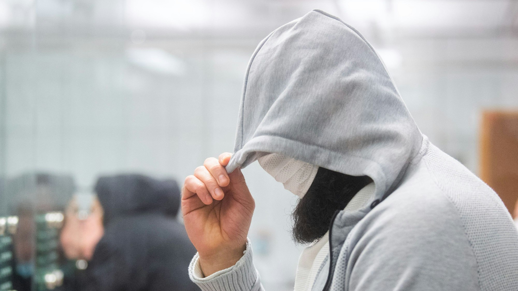 Abu Walaa, mutmaßlicher Anführer der Terrormiliz Islamischer Staat (IS) in Deutschland, steht im Gericht hinter einer Glasscheibe.