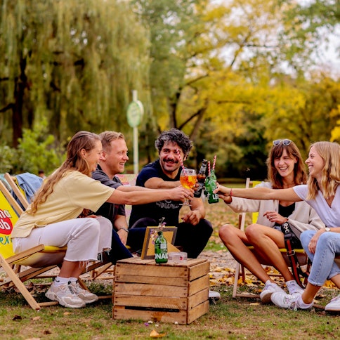 Junge Leute sitzen bei sonnigem und warmen Herbstwetter im Biergarten am Aachener Weiher in Köln.
