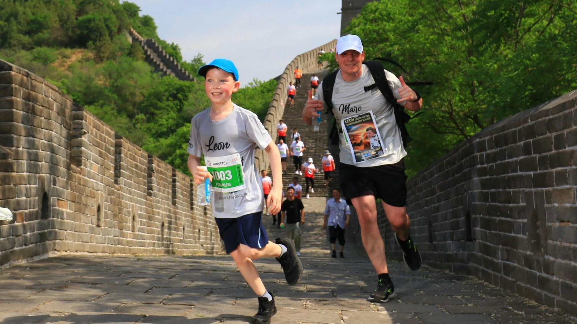 Leon und Vater Marc Marth tragen Kappen und laufen die Stufen der Chinesischen Mauer herunter.