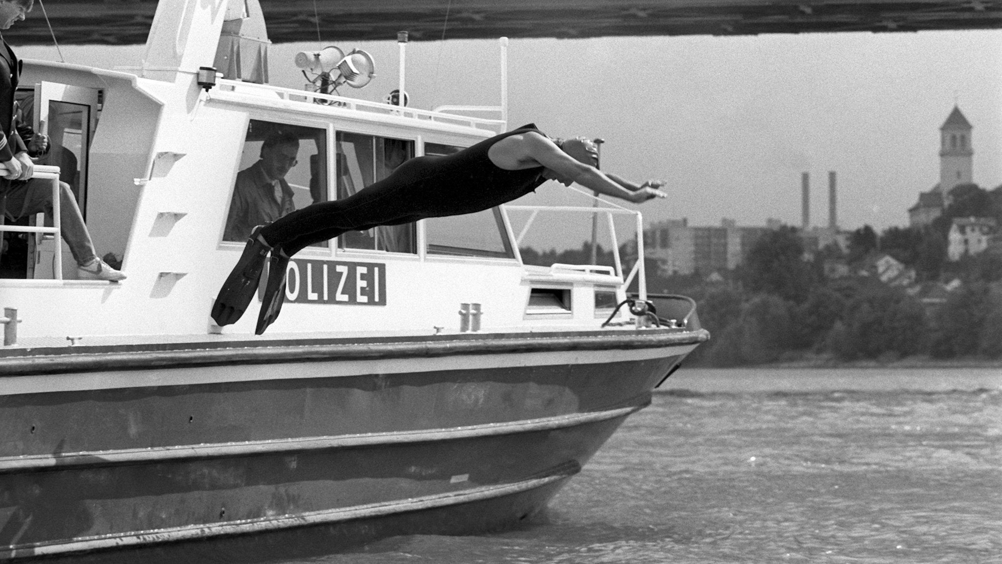 ARCHIV - 13.09.1988, Hessen, Mainz: Angetan mit einer Badekappe, einem Schutzanzug und Schwimmflossen, springt Klaus Töpfer (CDU), damaliger Bundesumweltminister, von Bord eines Polizeibootes in den Rhein. Der damalige Bundesumweltminister wollte mit seinem spektakulären Sprung beweisen, dass nach einer Reihe von Chemikalieneinleitungen die Flüsse wieder regenerierten. (zu dpa: «Ex-Umweltminister Klaus Töpfer gestorben») Foto: Roland Witschel/dpa +++ dpa-Bildfunk +++