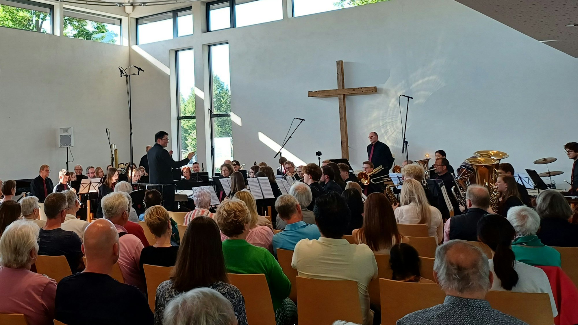 Zuschauer sitzen in einer Kirche, in der ein Orchester spielt.