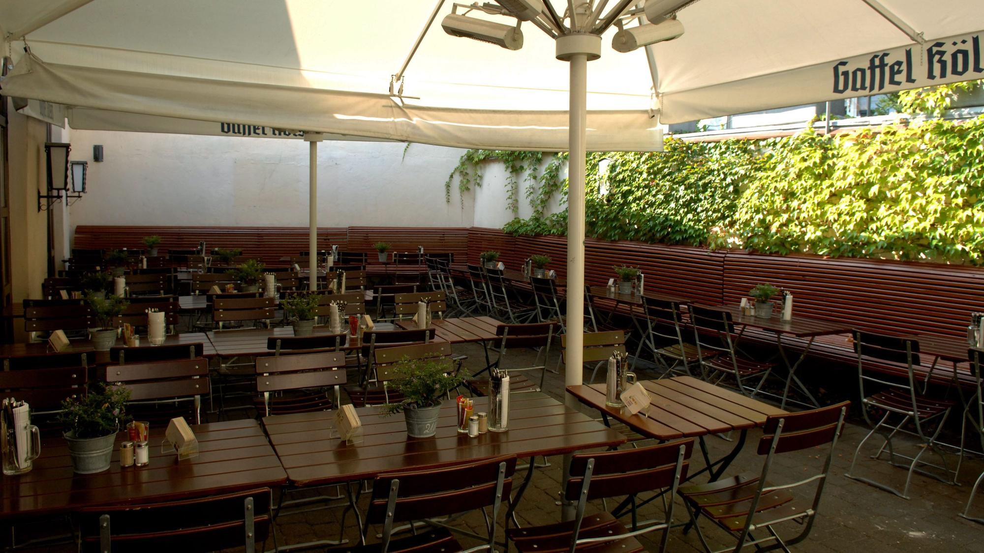 Biergarten bei Sonnenschein mit Tischen und Stühlen im Brauhaus ohne Namen.