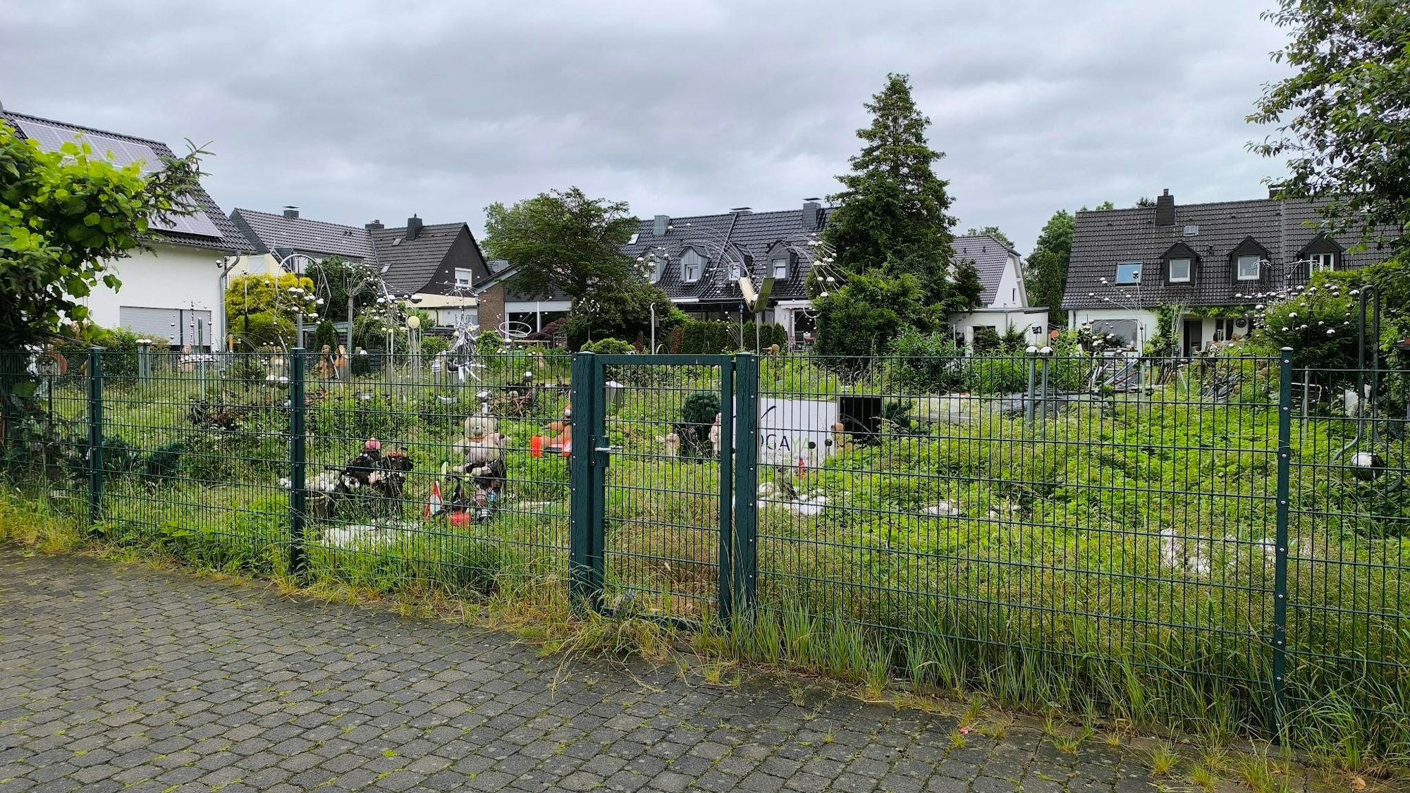 In diesem verwilderten Garten inmitten einer Wohnsiedlung in Leverkusen-Schlebusch sind einige Skulpturen und Figuren zu finden.