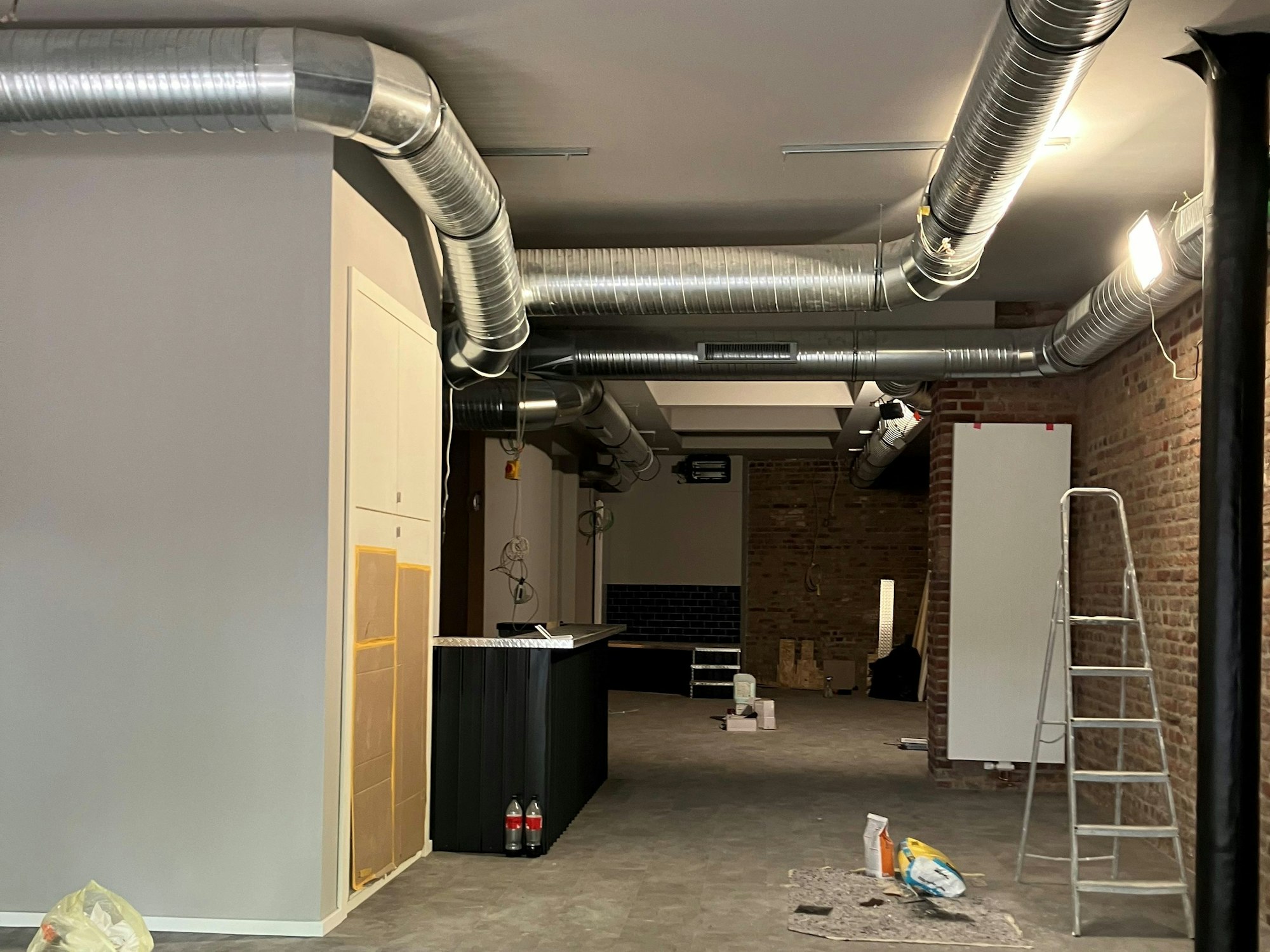 Blick in das neue Café an der Aachener Straße 2. Man sieht eine Theke. Der Boden ist neu gemacht.