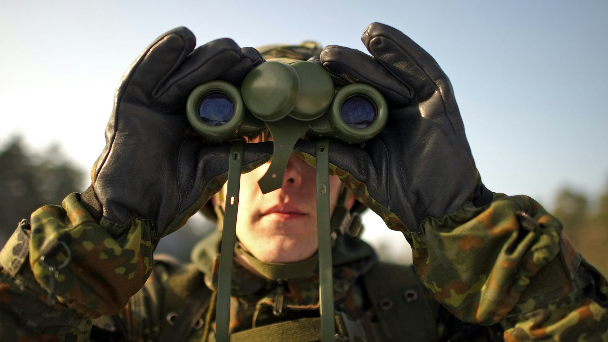 Ein Rekrut des Fernmeldebataillons 701 aus Frankenberg beobachtet auf dem Truppenübungsplatz Oberlausitz bei Nochten (Kreis Görlitz) während einer Schießübung den Luftraum mit einem Fernglas,