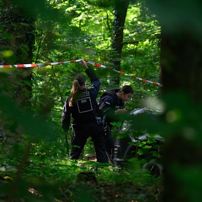 Eine Polizistin hebt ein Absperrband in einem Waldstück im sächsischen Döbeln nach oben. Dort hatte die Polizei bei der Suche nach der vermissten Valeriia eine Leiche entdeckt. Ob es sich dabei um das neunjährige Mädchen handelt, ist unklar.