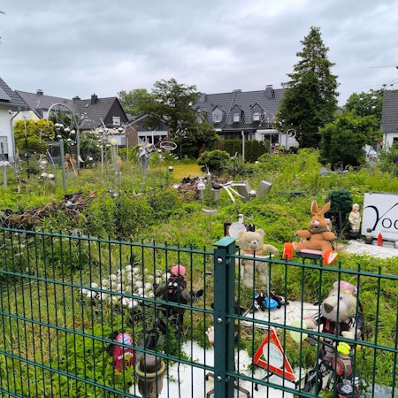 In diesem verwilderten Garten inmitten einer Wohnsiedlung in Leverkusen-Schlebusch sind einige Skulpturen und Figuren zu finden.