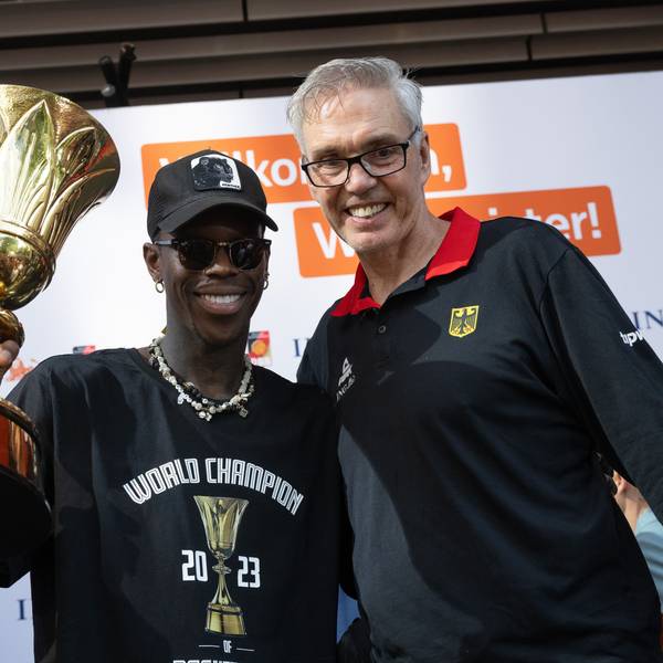 Dennis Schröder (l), Kapitän der Basketball-Nationalmannschaft, und Bundestrainer Gordon Herbert (r) jubeln beim Empfang des Teams in Frankfurt mit dem Pokal. Herbert verlässt die Nationalmannschaft nach Olympia.