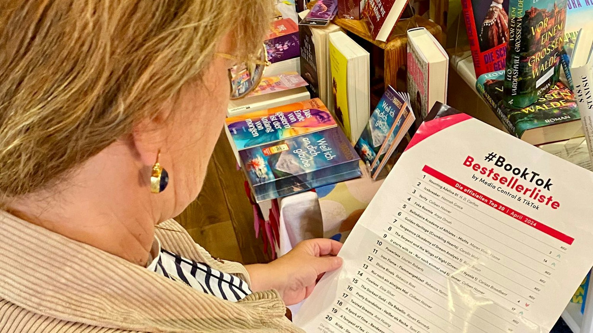 Renate Elsen hält ein Plakat in der Hand. Die Aufschrift: „BookTok Bestsellerliste“