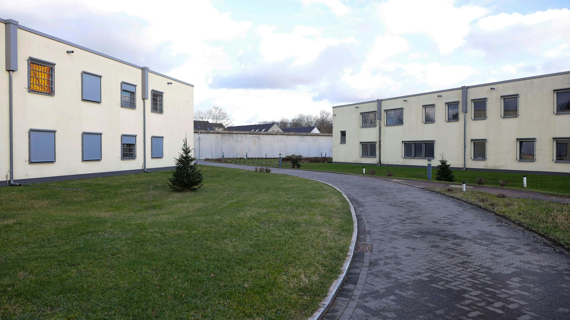 Man sieht Wohngebäude der Forensik, Grasflächen und einen Weg.